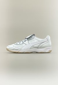 Λευκό sneaker χαμηλού προφίλ με υφασμένο δέρμα, μπεζ σόλα και λεπτομέρεια με ρίγα στο πλάι, εμφανιζόμενο σε προφίλ σε ουδέτερο φόντο.