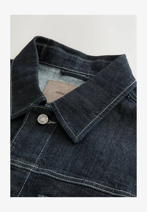 Denim jacket featuring a dark blue color, a pointed collar, silver metal button, and contrast stitching on the front panel. Textured fabric.