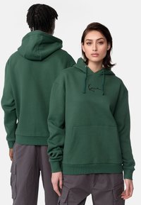 Sweat à capuche vert, en coton, au design à enfiler. Dispose d'une poche kangourou, d'une capuche avec cordon de serrage et d'un logo brodé sur la poitrine.