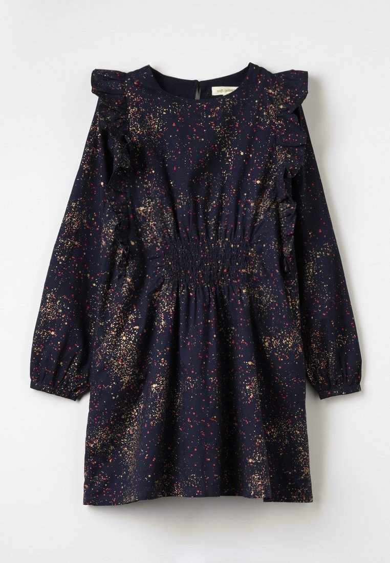 Marineblå kjole med flæsedetaljer, der har et rynket taljeafsnit og et farverigt sprøjtmønster i guld og rød. Lange ærmer med samlet manchet.