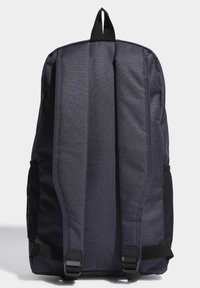 Mochila de tela azul marino con respaldo acolchado, correas ajustables, bolsillos laterales de malla y asa de transporte en la parte superior; diseño minimalista, sin patrones visibles.