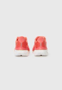 Zapatillas de correr de color coral brillante con una parte superior de malla texturizada, cuello acolchado y suela de goma blanca con acentos en oro claro.