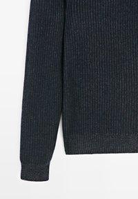 Maglione a coste scure con maniche lunghe, realizzato in un tessuto a maglia testurizzato. Presenta un orlo dritto e leggere variazioni di colore.