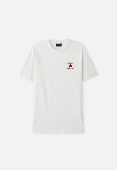 Balta medvilnė marškinėliai su trumpomis rankovėmis ir apvaliu iškirpimu. Kairėje krūtinės pusėje yra raudonas logotipas. Lygus paviršius, laisvas stilius.