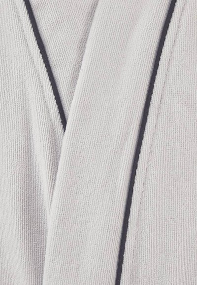 Κοντινό πλάνο για το λευκό κολάρο μιας υφασμάτινης ρόμπας μπάνιου με σκούρο περιθώριο κατά μήκος των ακρών.