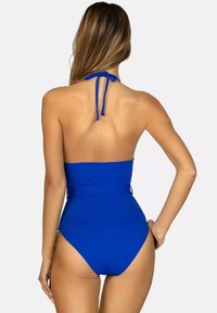 Niebieski jednoczęściowy strój kąpielowy z dekoltem na halter, dopasowany fason, wysoki stan i fakturowany materiał. Posiada wiązanie z tyłu oraz minimalistyczny styl.