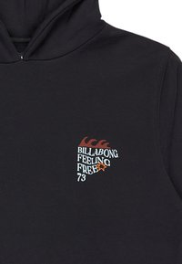 Felpa con cappuccio nera caratterizzata da una grafica colorata sul davanti con il testo "BILLABONG FEELING FREE 73" e accenti stilizzati a forma di onda.