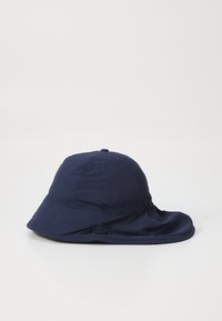 Chapeau seau bleu marine avec un large bord flexible, fabriqué en tissu léger avec une texture lisse et un subtil détail de couture.