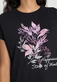 Černé tričko s květinovou grafikou v odstínech růžové a stříbrné, s textem "Happiness State of Mind" v kurzívním písmu.