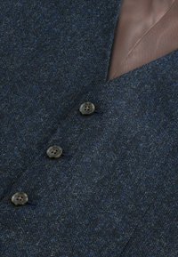 Marineblå struktureringstof blazer med to knapper, brunt for i herringbone-mønster og en skarp reversdesign.