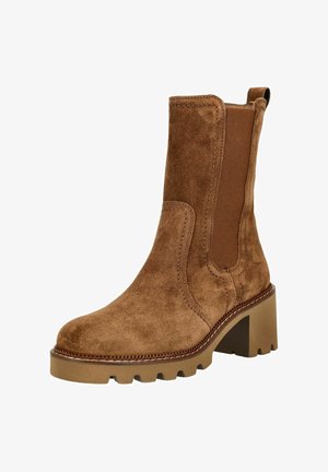 Bottine en suède marron avec des panneaux latéraux élastiques, un talon bloc, une tige texturée et une semelle en caoutchouc présentant un motif à crampons.