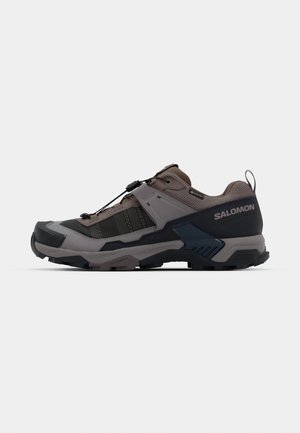 Outdoor shoe featuring a gray and dark blue design with textured fabric, sturdy sole, and adjustable lacing system for secure fit.