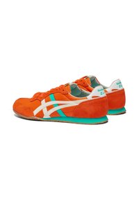 Sneakers in suede arancione con accentuazioni bianche e teal, caratterizzati da un design retrò, sovrapposizioni testurizzate e una suola in gomma.