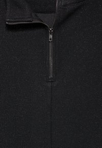 Maglia nera con zip sul davanti caratterizzata da una texture a coste, una zip di un quarto di lunghezza e una leggera lucentezza su tutta la stoffa. Finitura liscia al colletto.