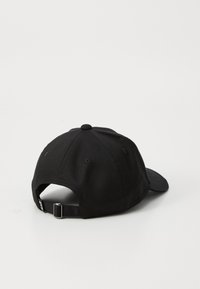 Boné de baseball de algodão preto com aba curva, strap ajustável e buracos de ventilação na parte de trás para respirabilidade.
