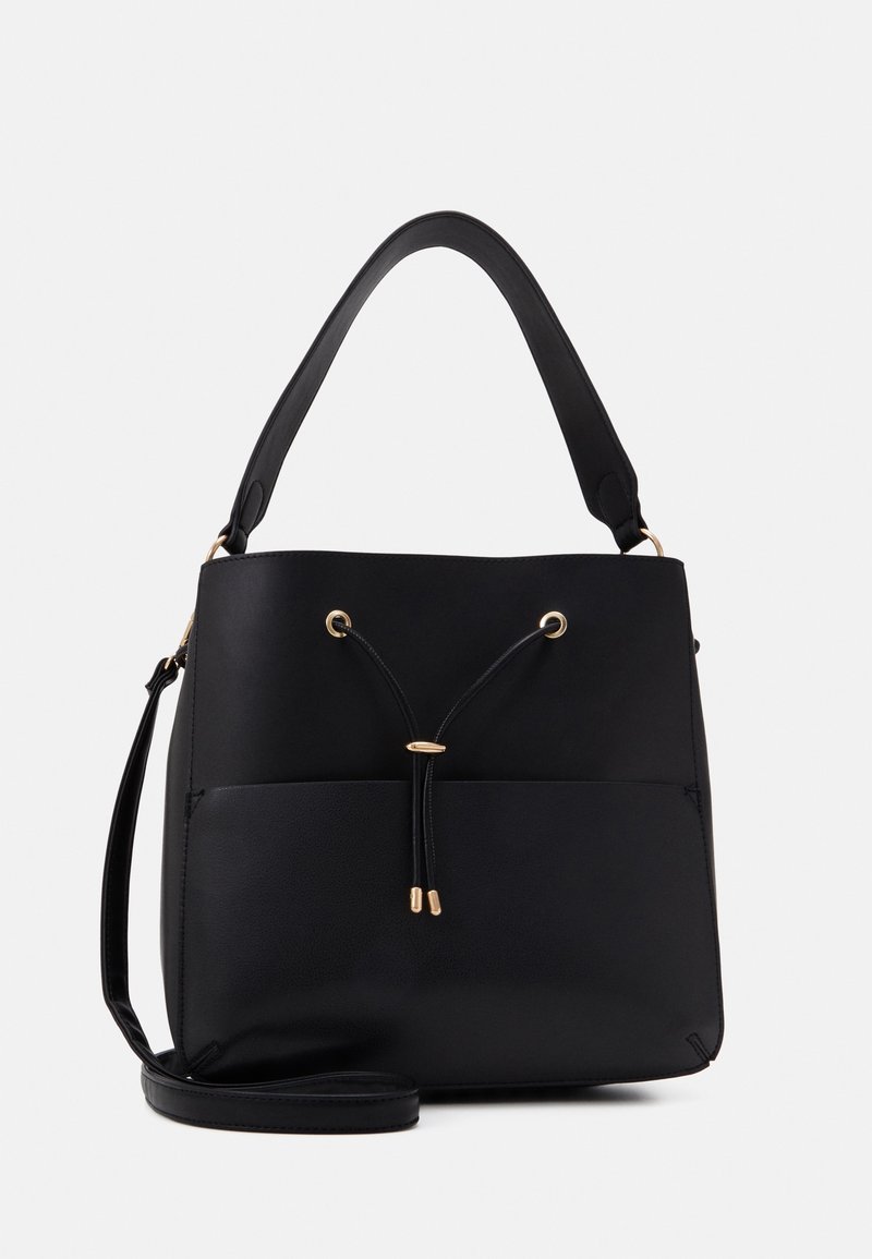 Sac à main noir avec une large anse, un détail à cordon sur le devant avec des accents dorés, et une longue bandoulière supplémentaire sous le sac.