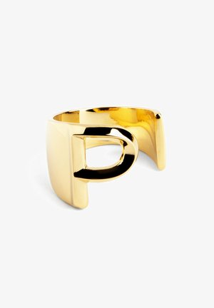 Anillo de pulsera de metal en tono dorado que presenta un diseño abierto con una forma "D" recortada. Acabado liso y brillante con un estilo moderno y minimalista.