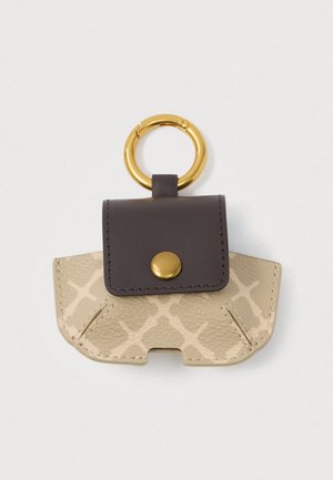 Pungă mică din piele bej și maro, cu un buton de aur și un inel mare de cheie din aur atașat.