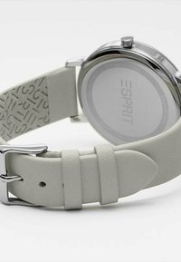 Silberne Edelstahl-Uhr mit einem hellgrauen Lederarmband, Schnallenverschluss und strukturiertem Gehäuse, das ein erhabenes Logomuster aufweist.