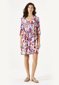 Korte mouw jurk met een kleurrijk abstract bladpatroon in roze, rood, blauw en beige, met een v-halslijn en een geraffineerde taille.