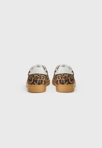 Leopardmønstrede sneakers med en tan gummisål, hvid læssetunge og polstret krave, der fremviser en tekstureret stofoverflade.
