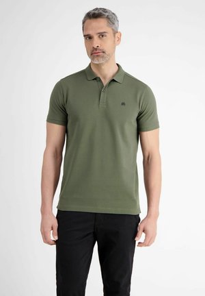 Olijfgroene polo met korte mouwen, een kraag en een klein logo op de borst; gedragen met zwarte broeken, minimalistisch ontwerp.