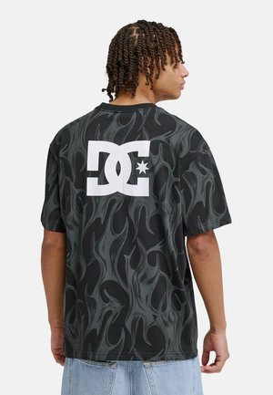 Zwart T-shirt met korte mouwen met een vlammenpatroon, een groot wit DC-logo op de achterkant en een ronde hals.