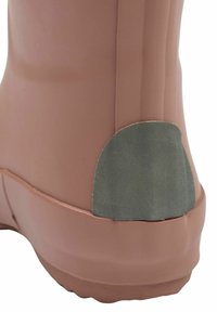 Rosa gummistövel med en texturerad grön detalj på hälen. Slätt material, rundad form och tjock sula för stabilitet.