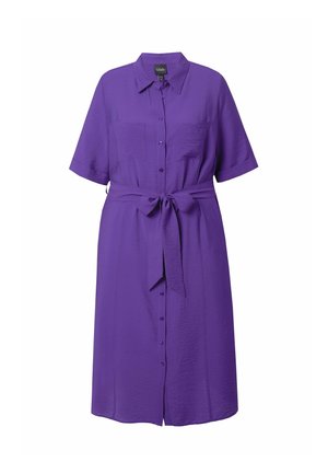 Robe violette à manches courtes, avec un lien à la taille et deux poches poitrine. Fabriquée en tissu léger avec une texture lisse.