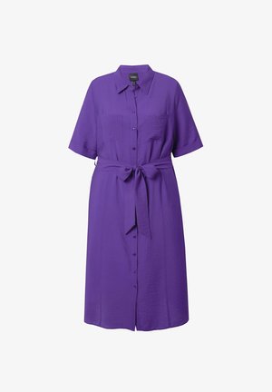 Fioletowa sukienka zapinana na guziki z krótkimi rękawami, związywana w talii i z dwiema kieszeniami na piersi. Wykonana z lekkiego materiału o gładkiej teksturze.