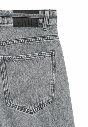 Pantalon en jean gris clair montrant la poche arrière, la passants de ceinture, et une étiquette de marque noire rectangulaire près de la taille.