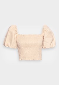 Top court à manches courtes en beige avec une texture smockée, présentant des manches bouffantes et un col volanté. Confectionné en tissu léger.