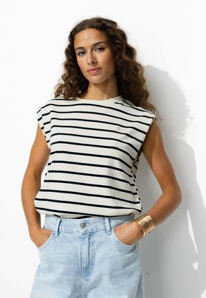 Haut sans manches en coton rayé blanc et bleu marine avec un col rond et un détail brodé "GOOD MOOD", associé à un denim bleu clair.