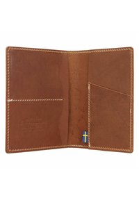 Bruine leren portemonnee met gestikte randen, voorzien van twee kaartsleuven en een klein accent van de Zweedse vlag. Gemaakt van plantaardig gelooid leer.