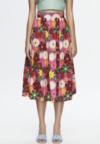 Bloemmotief midi-rok in roze, rood en groen, met een gegatherde taille en gelaagd ontwerp, gecombineerd met blauwe instappers.