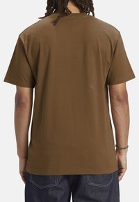 Brown cotton t-shirt with short sleeves and a relaxed fit. Smooth texture with a classic crew neckline, no visible logos or designs.