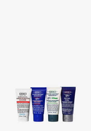 Vier Kiehl’s Hautpflege-Tuben, darunter Ultra Facial Cleanser und drei rasurbezogene Cremes, nebeneinander auf weißem Hintergrund angeordnet.