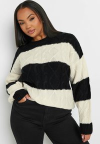 Krämfärgad och svart randig kabelstickad tröja med rund halsringning och långa ärmar, med en strukturerad mönster och ribbade muddarna.