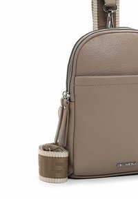 Hellederne Crossbody-Tasche mit silbernem Beschlag, Reißverschluss, Vordertasche und einem geflochtenen Tragegurt mit einem gemusterten Band.