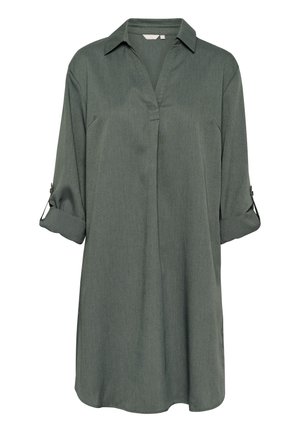 Tunique verte en tissu doux avec un col à revers, des manches retroussables et un ourlet légèrement arrondi, offrant une coupe décontractée.