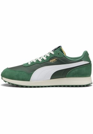 Groene en witte Puma Helsinki sneaker met een bovenwerk van suède en nylon, witte veters en een gestructureerde zool, zijaanzicht op een witte achtergrond.