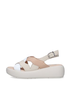 Sandalo platform in pelle beige e bianco con cinturino regolabile alla caviglia e motivo decorativo traforato su sfondo bianco.
