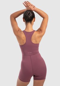 Bodysuit sin mangas burdeos con un diseño de espalda al aire y pantalones cortos a mitad del muslo, hecho de una tela lisa y elástica. Logo presente en la parte baja de la espalda.
