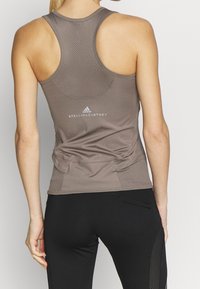 Brun nät-bak tanktop med en figurnära design, med platta sömmar och Adidas by Stella McCartney-logotypen på ryggen.