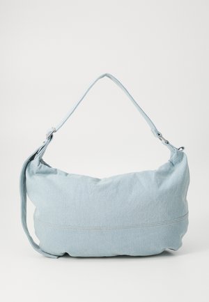 Svetlo modra denimska torba za ramo zaobljene oblike, z nastavljivim trakom in diskretnimi šivi ob spodnjem robu. Mehak na dotik.