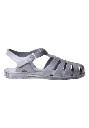 Grå gennemsigtig plastik sandal med lukket snude burdesign, justerbar spænde rem og flad sål.