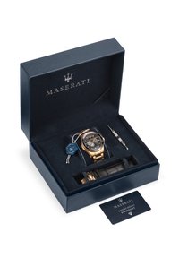 Maserati ur i en marineblå kasse, med sort urskive, guldfarvet metalarmbånd og læderrem. Inkluderer et prøveskilt og værktøjssæt.