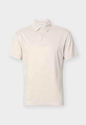 Beiges Poloshirt mit kurzen Ärmeln, dezentem diagonalem Muster, drei Knöpfen und klassischem Kragen vor einfarbigem Hintergrund.