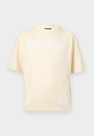 Μπεζ κοντομάνικη μπλούζα με την επιγραφή "DSQUARED2" στην περιοχή του στήθους και τον αριθμό "64" τυπωμένο κοντά στο κάτω τελείωμα μπροστά.