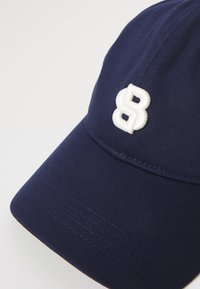 Tengerészeti baseball sapka pamutból, ívelt karimával, a bal első panelen fehér hímzett 8-as számmal.